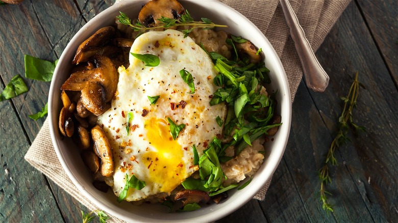 Oatmeal topped with egg and vegetables