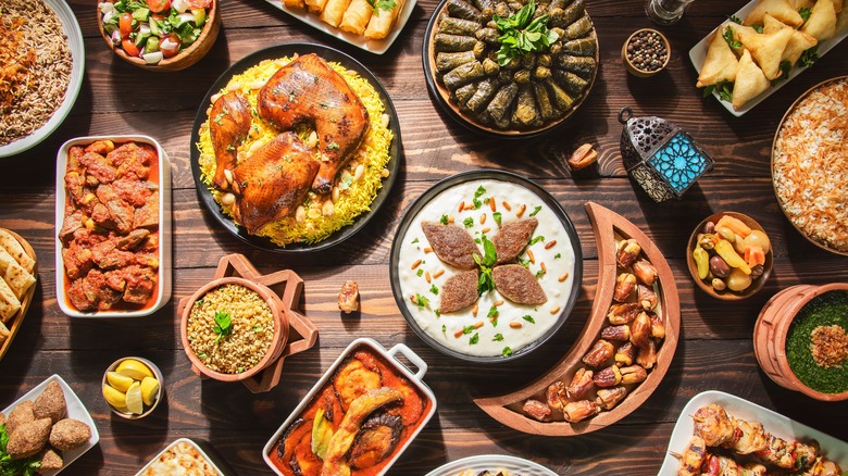 A Middle Eastern iftar buffet arranged on a wooden table.