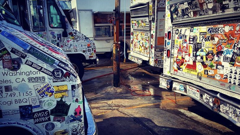 Parked Kogi food trucks covered in colorful stickers