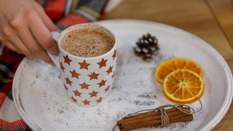 Mug of hot chocolate with oranges