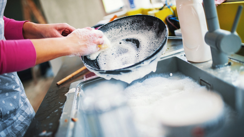 Person washing a black pan