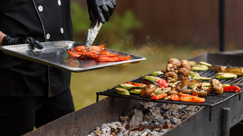 Person making charred vegetables on grill