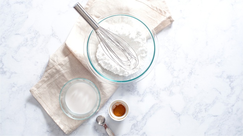 Powdered sugar and milk in bowls 