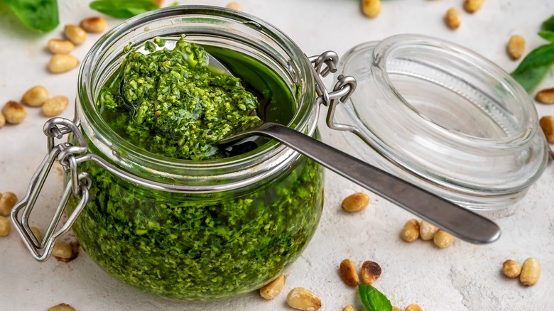 spoon scooping pesto from jar