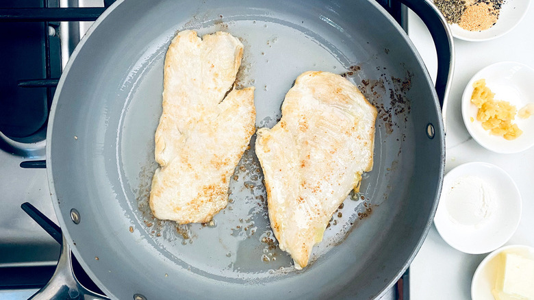 chicken breasts cooking in pan