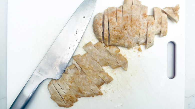 chicken strips on cutting board with knife