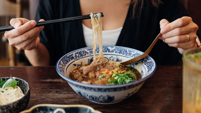 woman eating pho