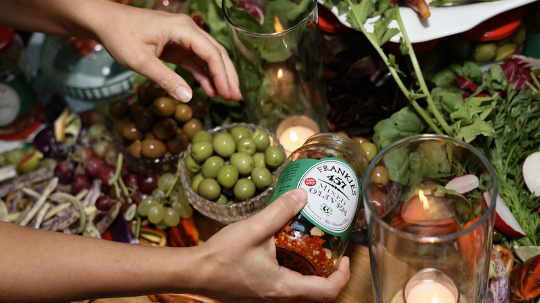 Person restocking olive bowl