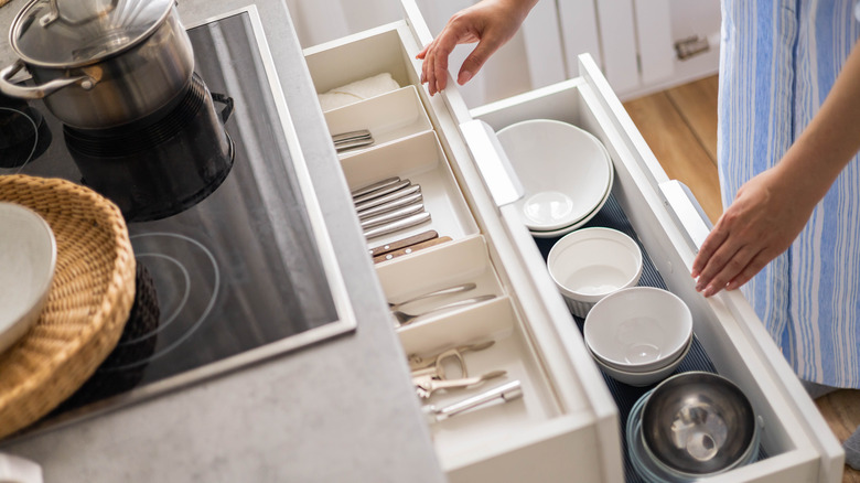 Person getting dishes from drawers