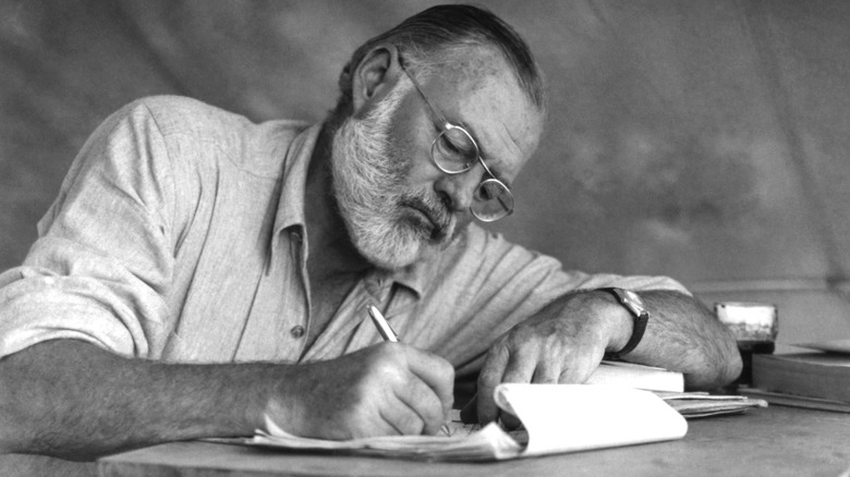 Ernest Hemingway writing with pen and paper