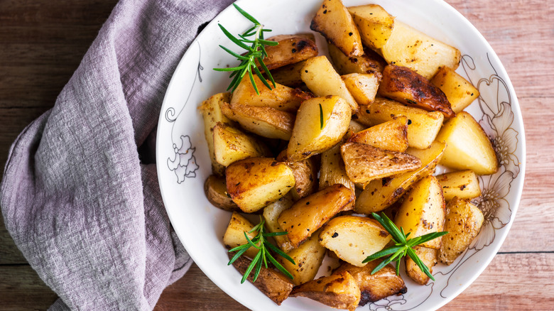 Plate of roasted potatoes with rosemary sprigs