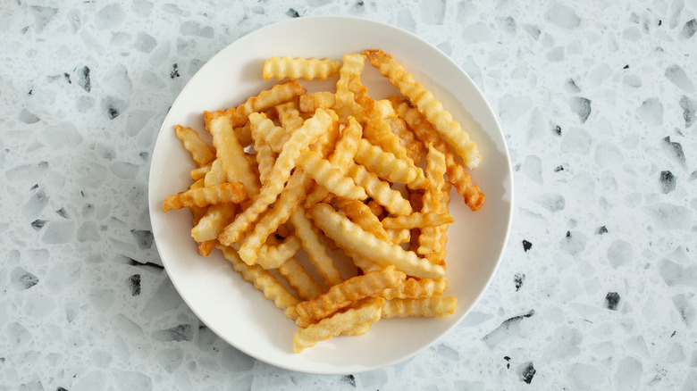 White plate of crinkle cut fries