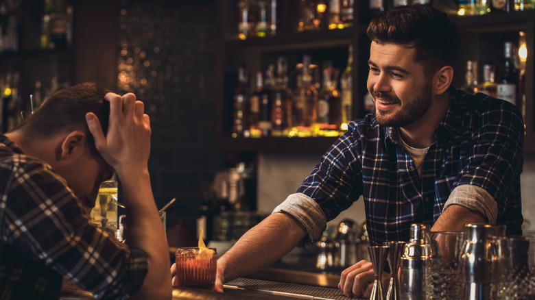 A bartender helping a customer