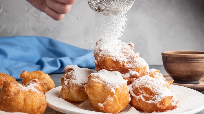 Sprinkling beignets with sugar