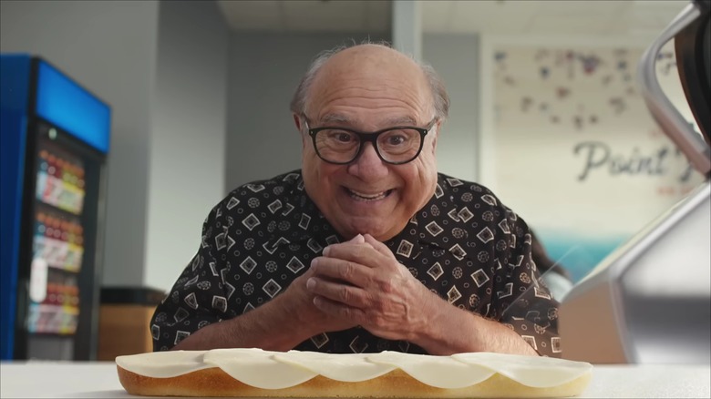 Danny DeVito smiling at sandwich