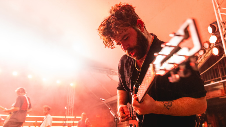 Man performing music on stage guitar