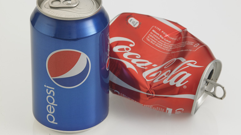 Pepsi can with crushed coke can