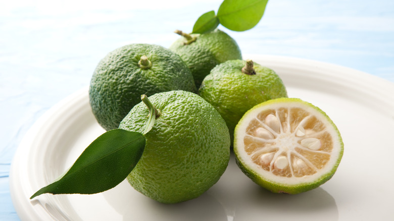 green yuzu fruits on white plate