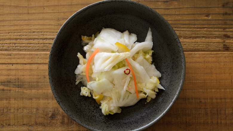 pickled cabbage in black bowl with yuzu fruit