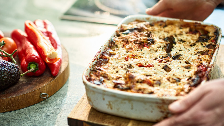 Hands holding homemade lasagna