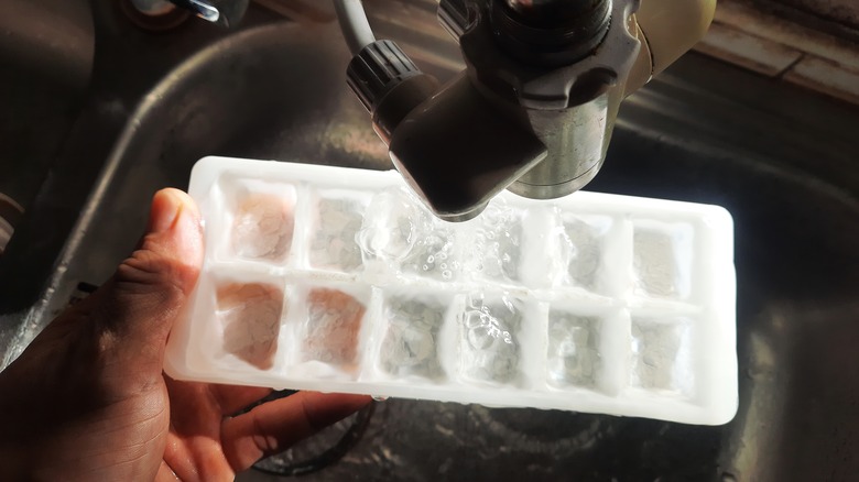 Ice cube tray held under kitchen faucet