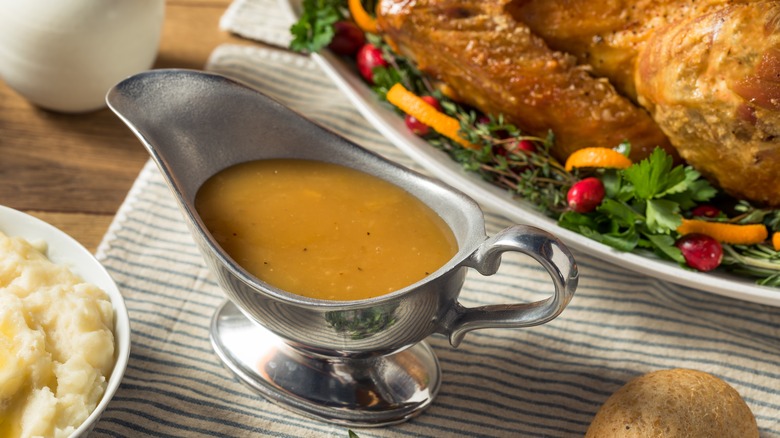 Gravy boat sits next to Thanksgiving turkey