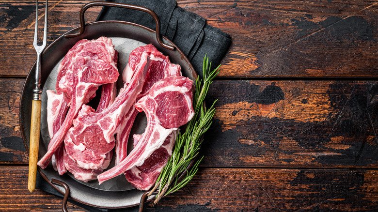 Uncooked lamb chops on plate