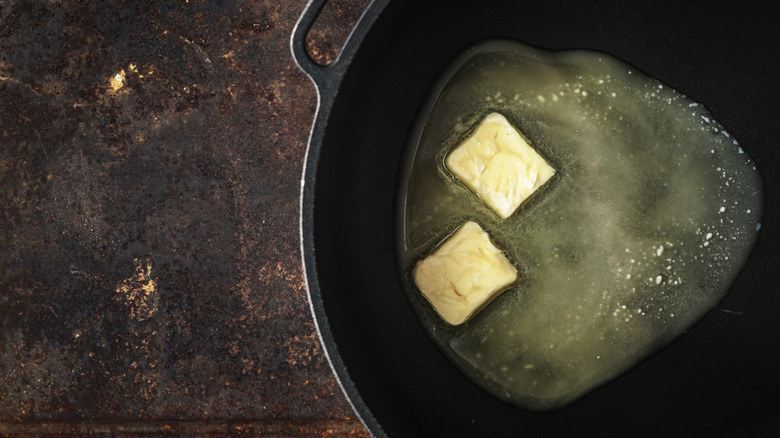 pieces of butter melting in skillet