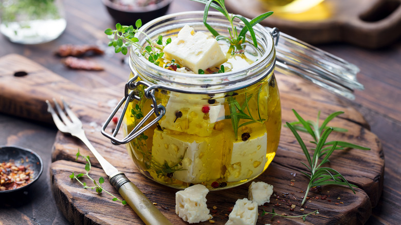 cubes of feta cheese in jar of olive oil