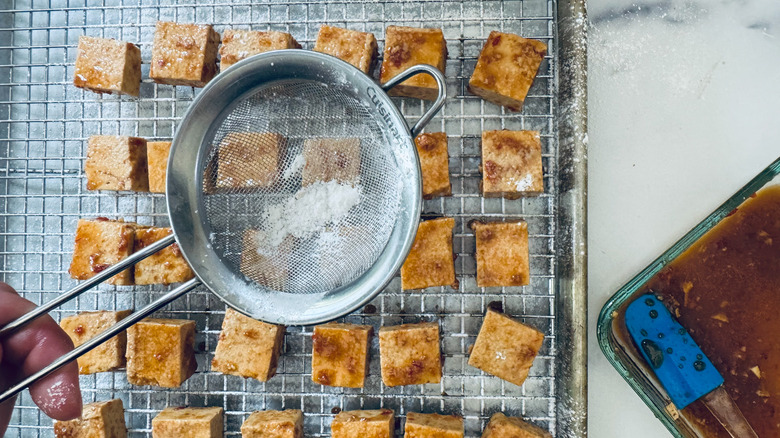 sprinkling powdered mixture on tofu