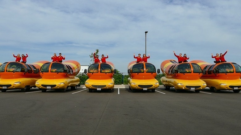 Line of hotdoggers in their Wienermobiles