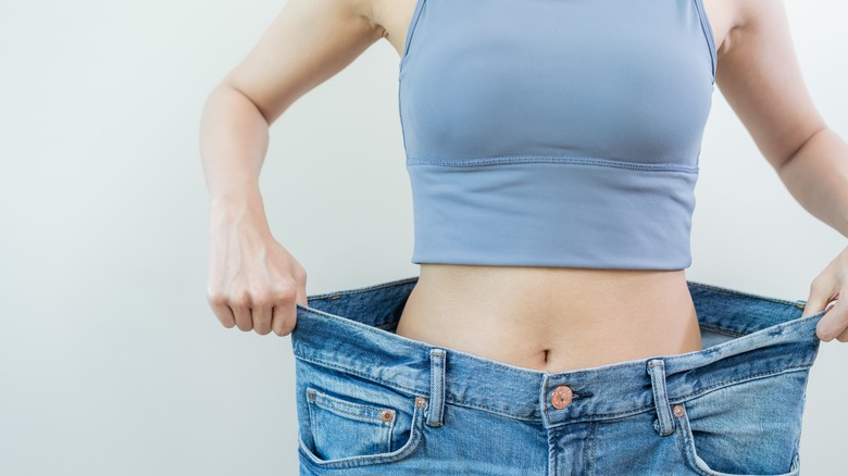 woman holding larger pants