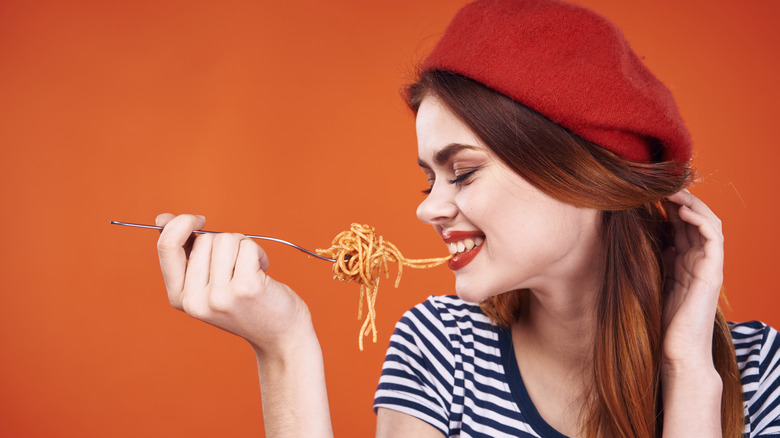 Woman biting into pasta