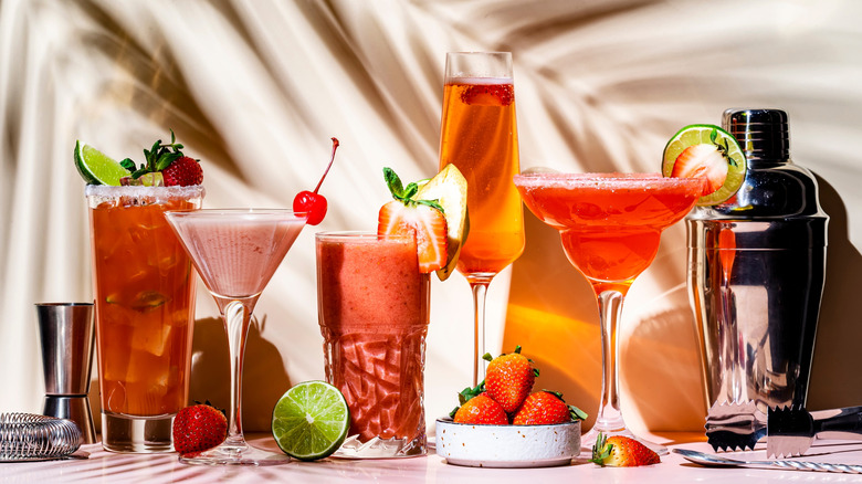 Cocktails with freshly prepped garnishes like strawberries, cherries, and lemon wedges