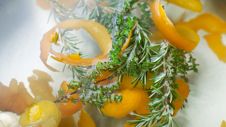 orange peels and rosemary floating in water