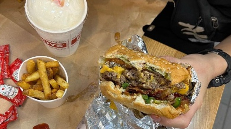 customer eating Five Guys over a brown paper bag