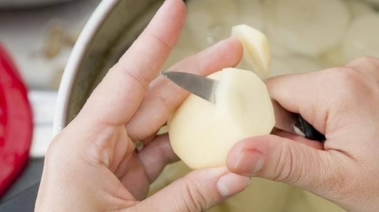 hands cutting potato