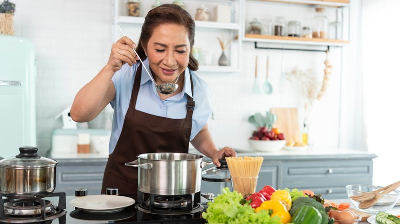 Person tasting the soup they're cooking