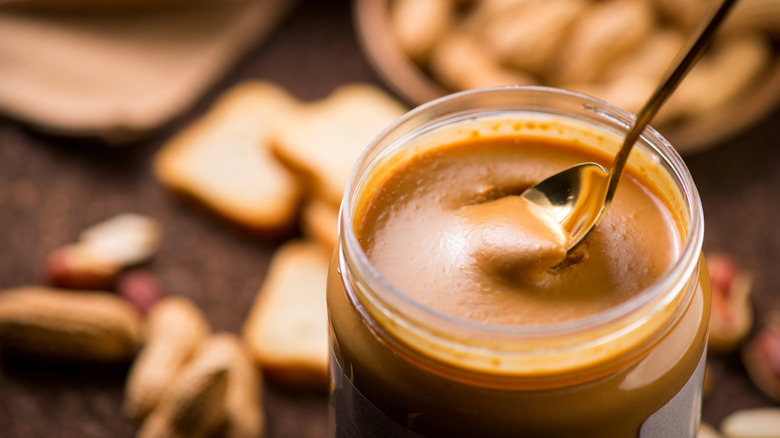 jar of creamy peanut butter with a spoon inside