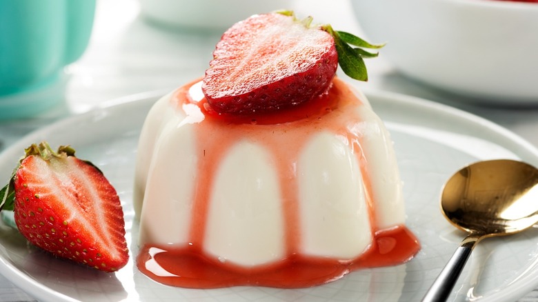 plated panna cotta with fresh strawberries and fruit sauce