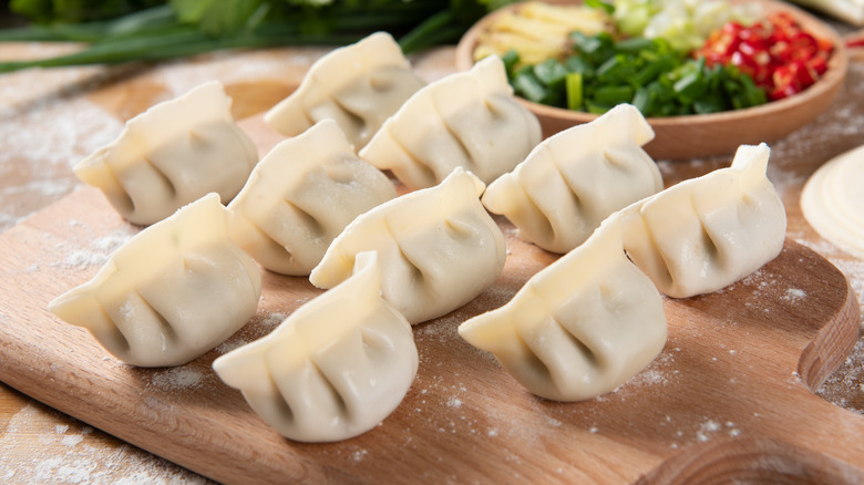 Uncooked Jiaozi on a cutting board