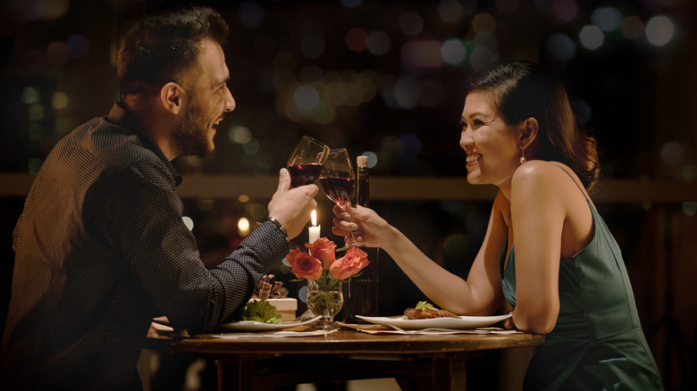 couple on a romantic dinner date toasting with wine