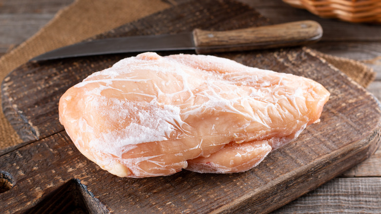 Frozen chicken on cutting board