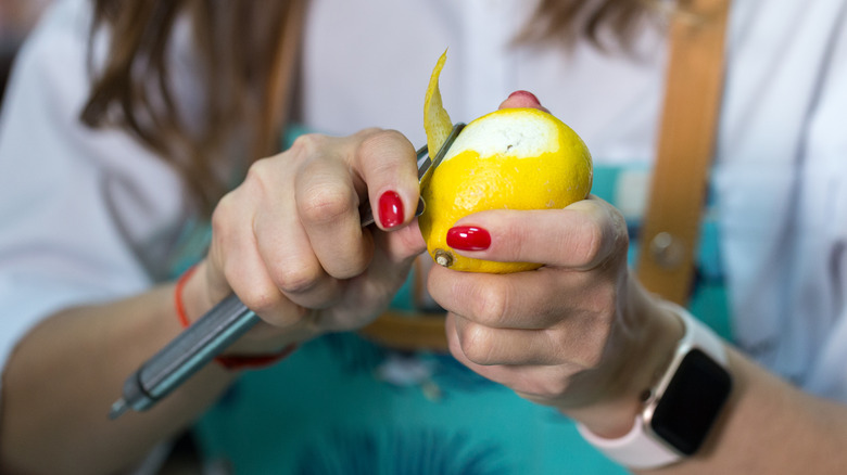 Person peeling lemon