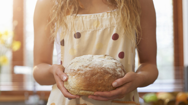 holding loaf of fresh bread