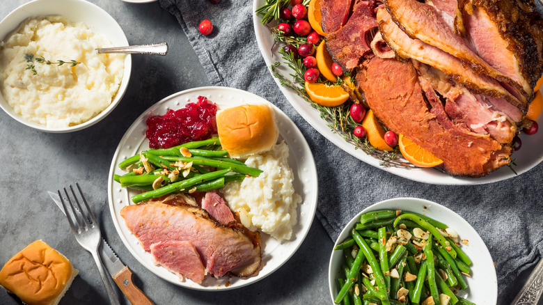 Christmas dinner plate with ham, mash, green beans, roll and cranberries