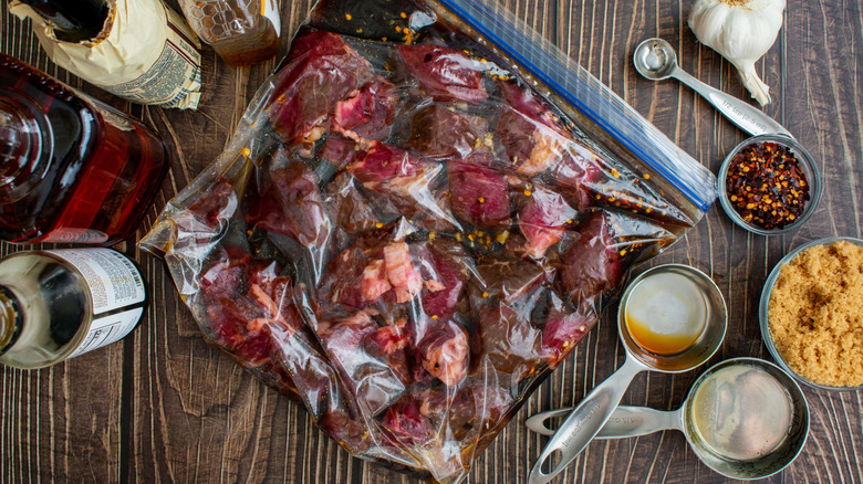 Marinated beef packed in a ziplock bag kept on a wooden table.