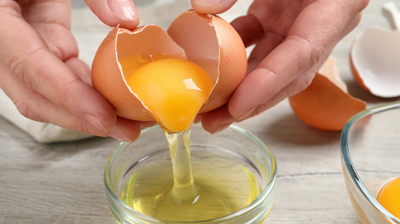 person separating egg yolks from whites