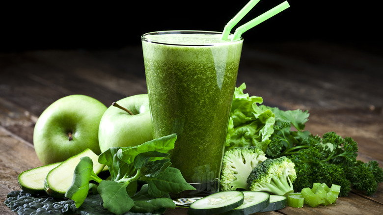 Green juice surrounded by produce