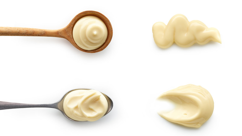 Mayonnaise in spoons top view isolated on white background